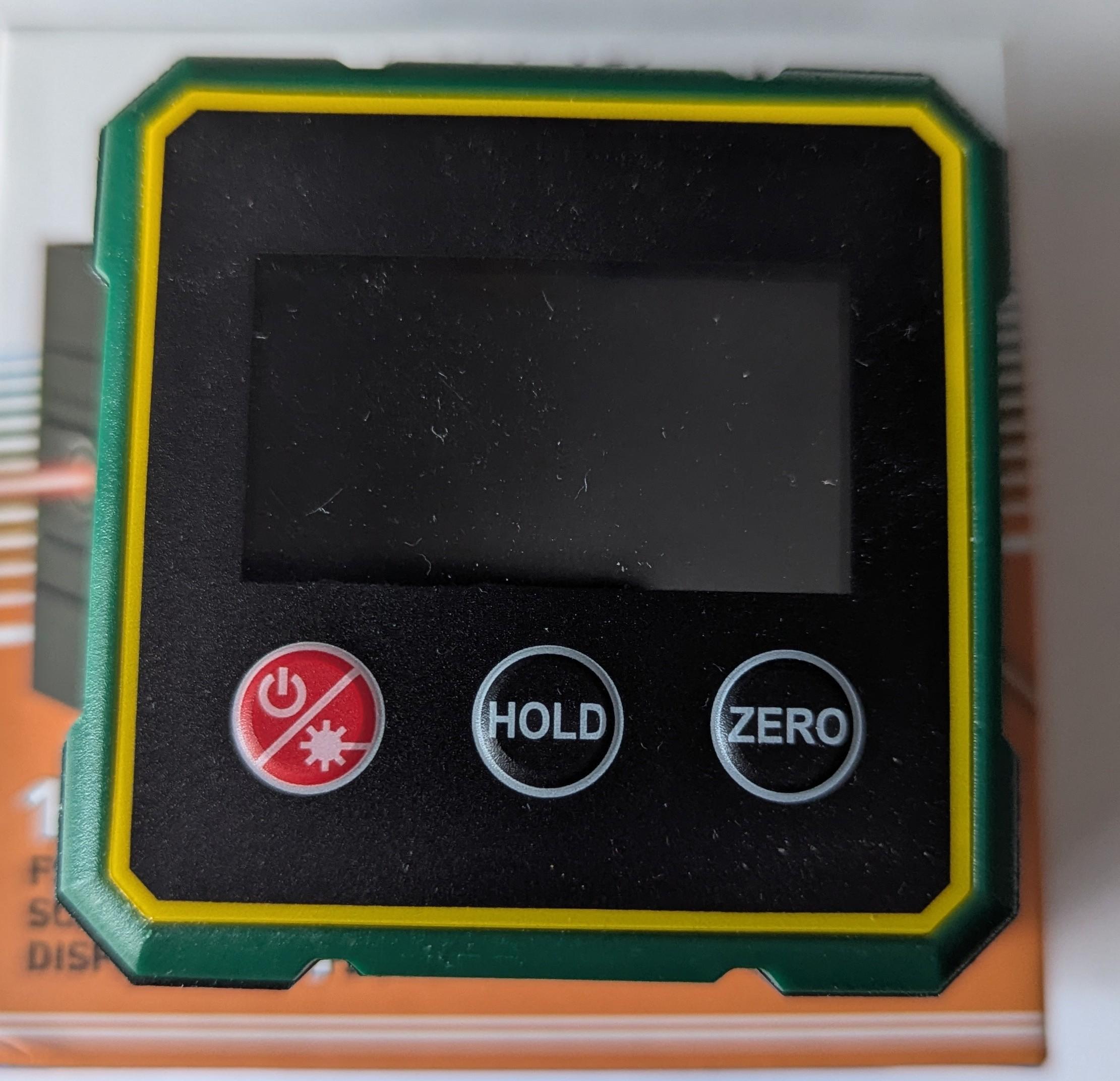 The device itself. It&rsquo;s a green and yellow and black plastic Square with a red button for power and laser and two black buttons labelled hold and zero. There&rsquo;s a display as well but it&rsquo;s not showing anything. It feels very plasticky